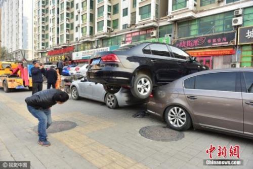 资料图 某地一男子在倒车时，不慎从1米高的台阶跌落，“骑”上台阶下停放的两辆轿车，所幸没有造成人员伤亡。图片来源：视觉中国
