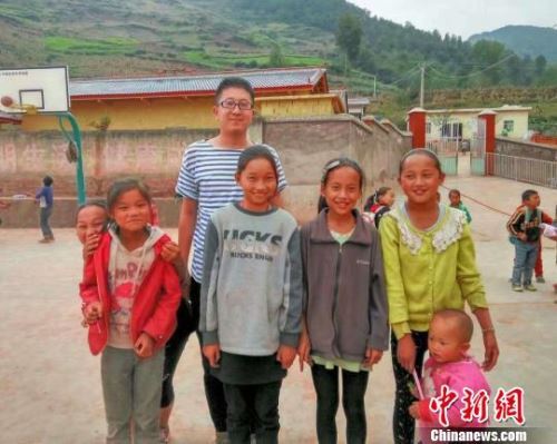 图为杨早龙和大凉山的孩子们在一起。　受访者供图 摄
