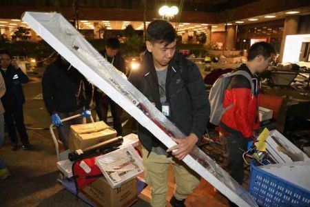  多名警员將於理大內搜集的证物，包括弓弩等搬上货车运离校园。 香港中通社图片