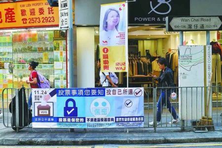 香港新一届区议会选举於10月22日举行。图为行人走过湾仔道边的选举標语牌